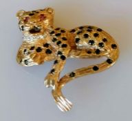 A Cartier-style 9ct yellow gold leopard brooch decorated with ruby eyes, diamond collar and sapphire