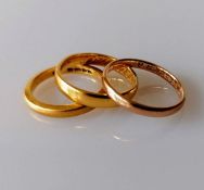 Two 22ct yellow gold wedding bands, sizes M, K 1/2, 7.94g and another 9ct gold, size N, 1.57g (3)