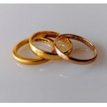 Two 22ct yellow gold wedding bands, sizes M, K 1/2, 7.94g and another 9ct gold, size N, 1.57g (3)