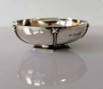 An Art Deco silver bowl with a planished, stylized design on an hexagonal base