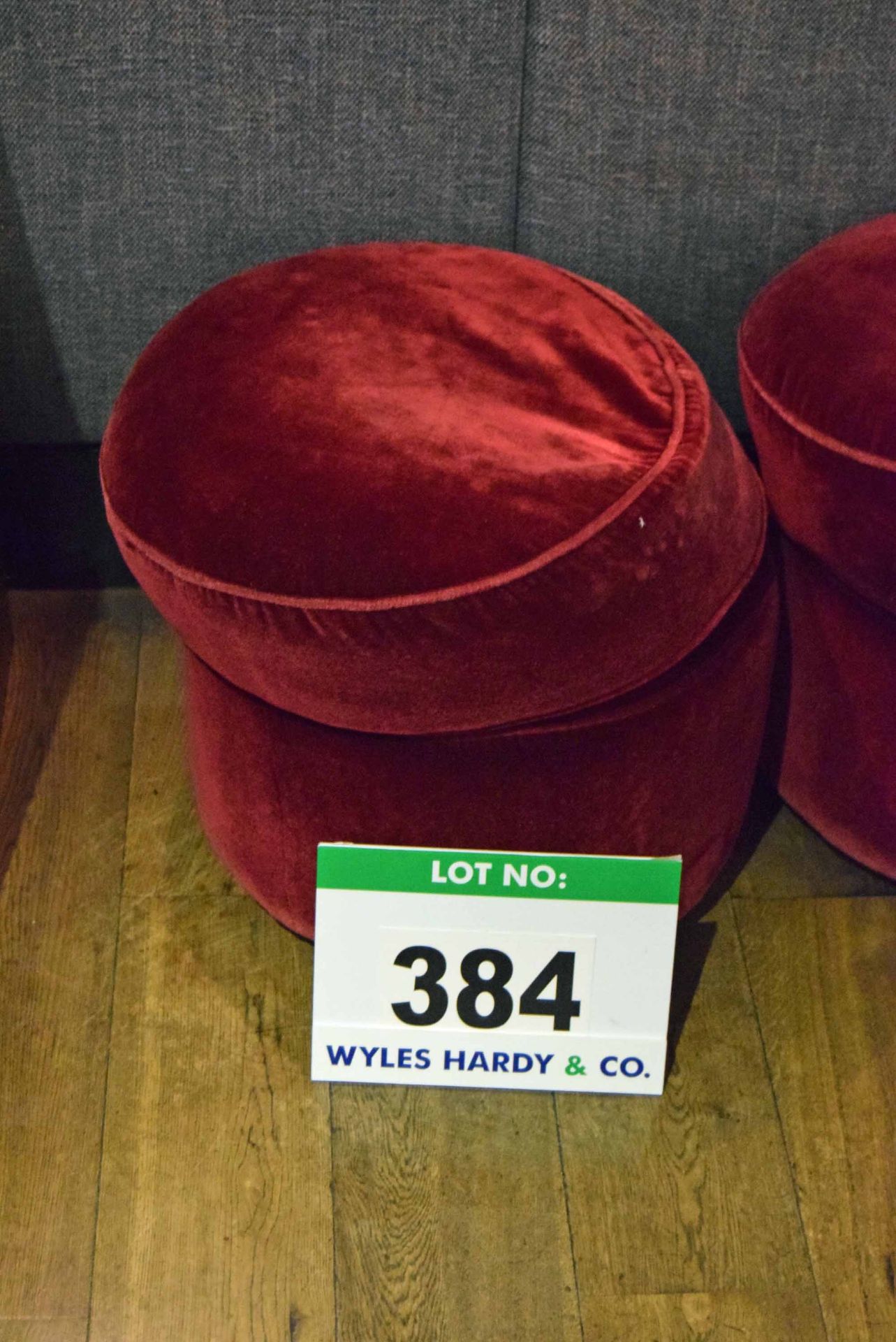 A Red Velour Upholstered Muffin Topped Pouffe