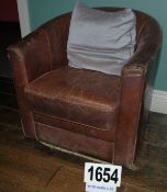 A Brown Leather Upholstered Tub Style Arm Chair with Removable Seat Cushions and Grey Fabric Scatter