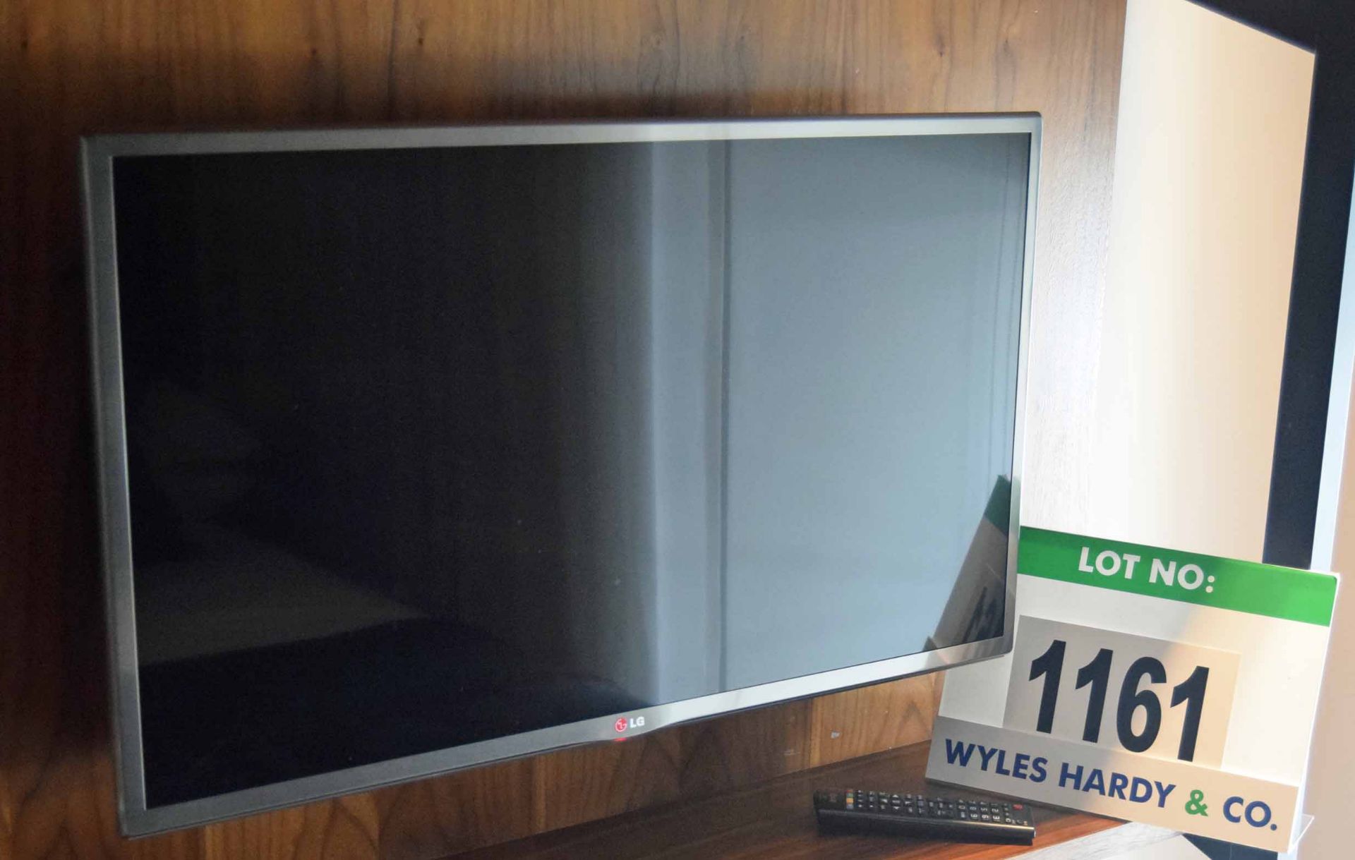 An LG Model 32UB650V Smart Television on a Fixed Wall Bracket with Hand Held Remote Control