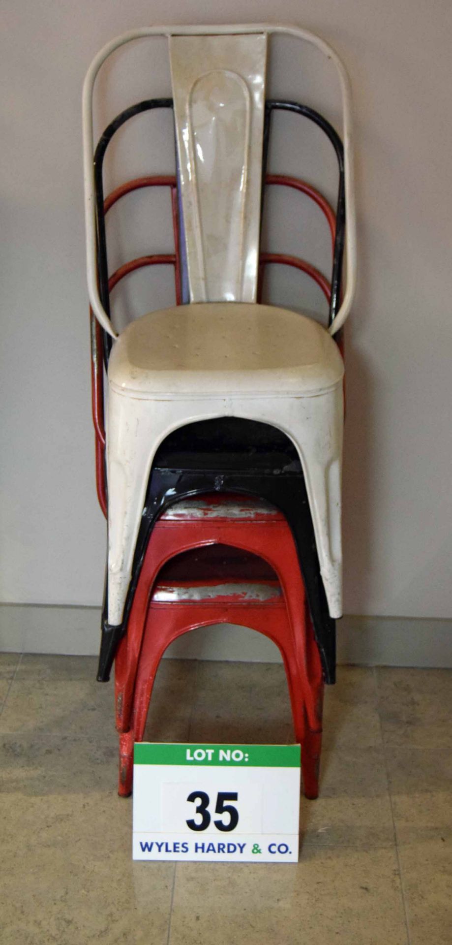 A Set of Four Pressed Steel Stacking Patio/Balcony/Bistro Chairs (One White, Two Red and One Black)