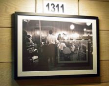 A Framed and Glazed Wall Hung Black and White Photographic Print Depicting a 1960s Scene from an