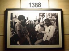 A Framed and Glazed Black and White Photographic Print Depicting the Recording of a Conversation