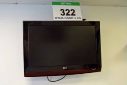 An LG 32 inch Flat Screen Television with Integral DVD Player and Hand Held Remote Control on a Wall