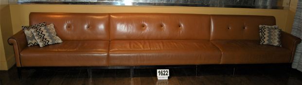 A Tan Leather Upholstered Seven Seater Couch with Black Buttoned Back Cushioning and Piping a