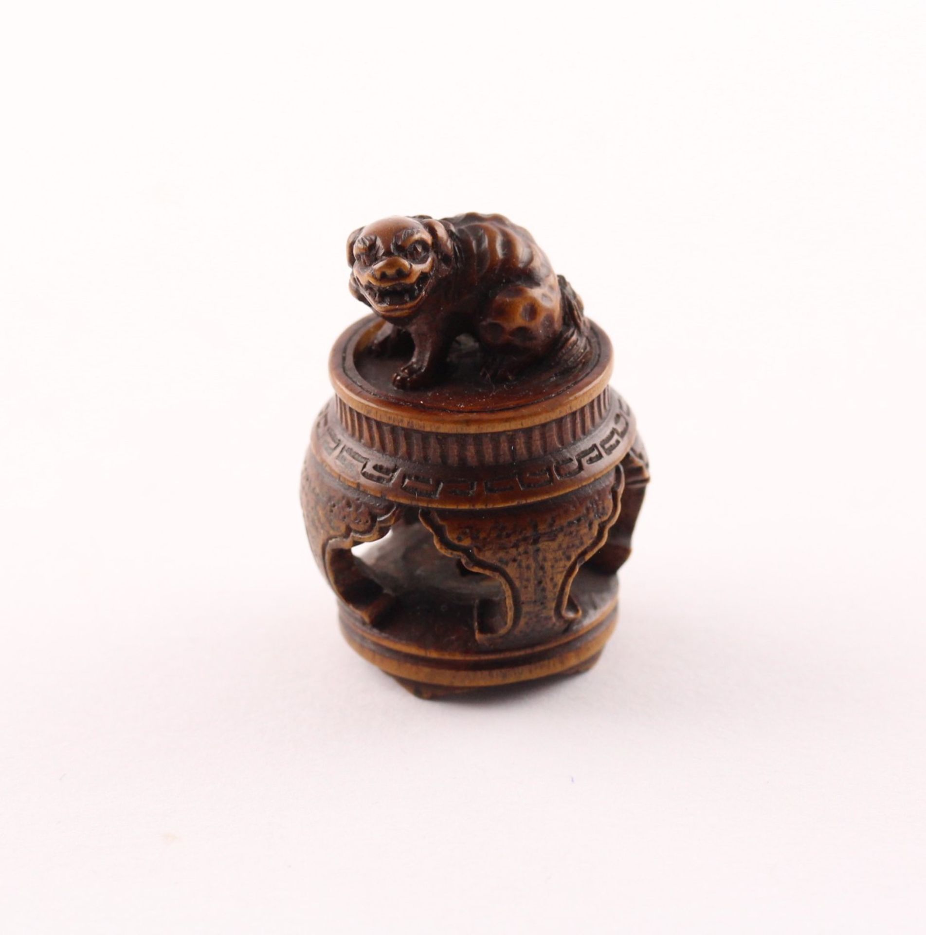 NETSUKE SHISHI AUF EINEM TISCH,