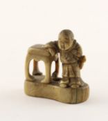 <de>NETSUKE KNABE AN EINEN TISCH GELEHNT, Elfenbein, geschwärzt graviert detailreich gearbeitet, sch