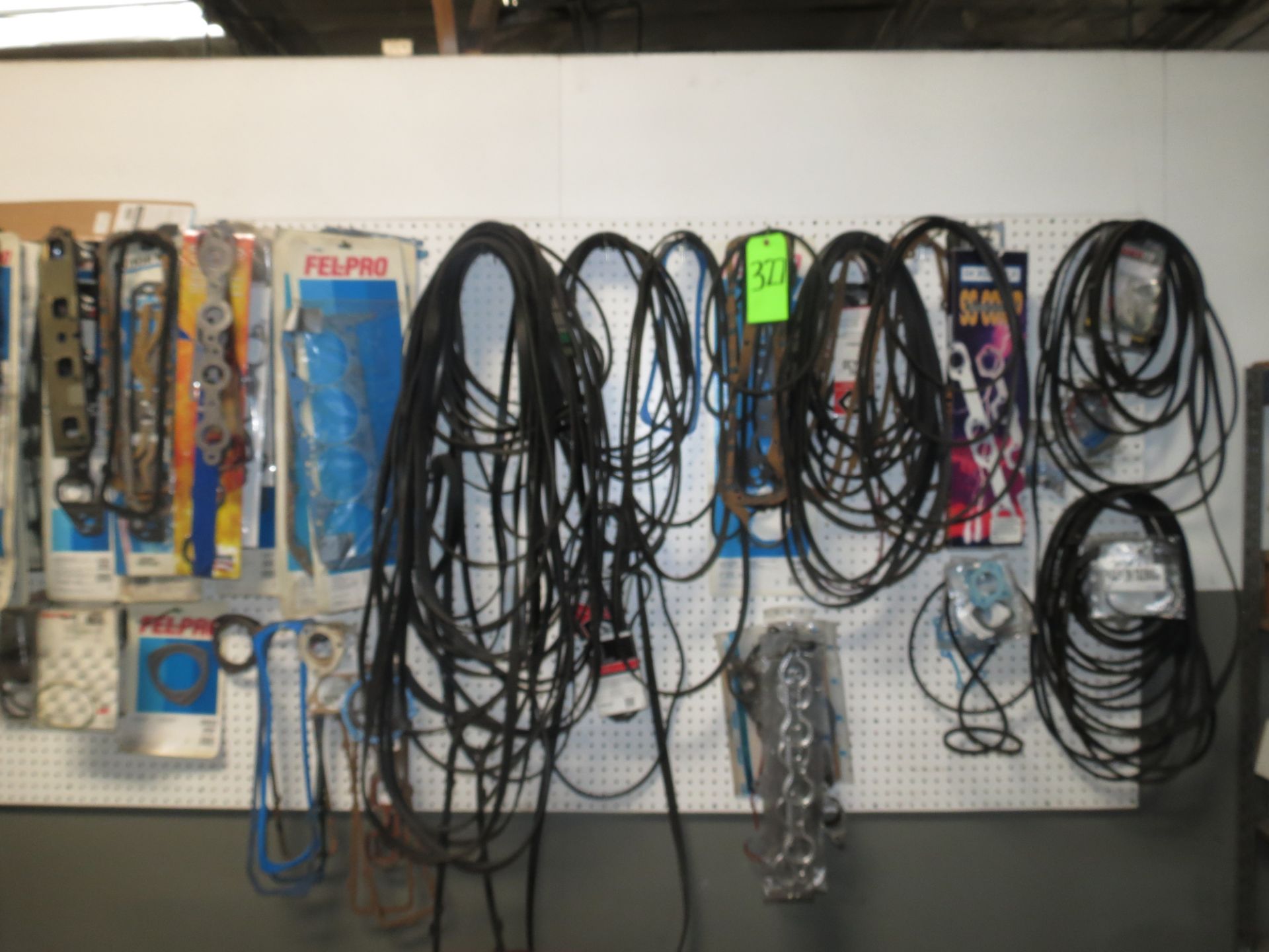 LOT OF ASSORTED BELTS & GASKETS ON WALL