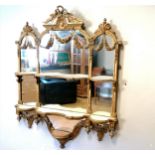 Regency giltwood wall mirror with swag decoration and shelf detail. Bottom shelf detail has become