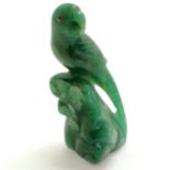 Oriental hand carved figure of a parrot on a rock in green jadeite/jade and has two rubies for eyes.