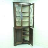 Antique mahogany corner cupboard with astral glazed top with shelves covered in a cream shot silk
