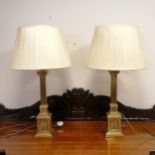 A pair of brass column lamp bases with silk shades total height 82cm x base 14cm x 14cm