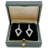 18ct hallmarked white gold diamond channel set earrings with 18ct gold heart shaped backs in
