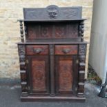 A continental carved Oak servery cupboard with lion detailing 128cm wide x 24cm deep x 180cm high