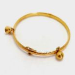 Chinese gold marked high carat bangle decorated with 2 bells, screw down safety catch approx. 6cm