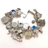Unmarked silver charm bracelet with numerous charms inc boot, poodle, teddy bear etc - total