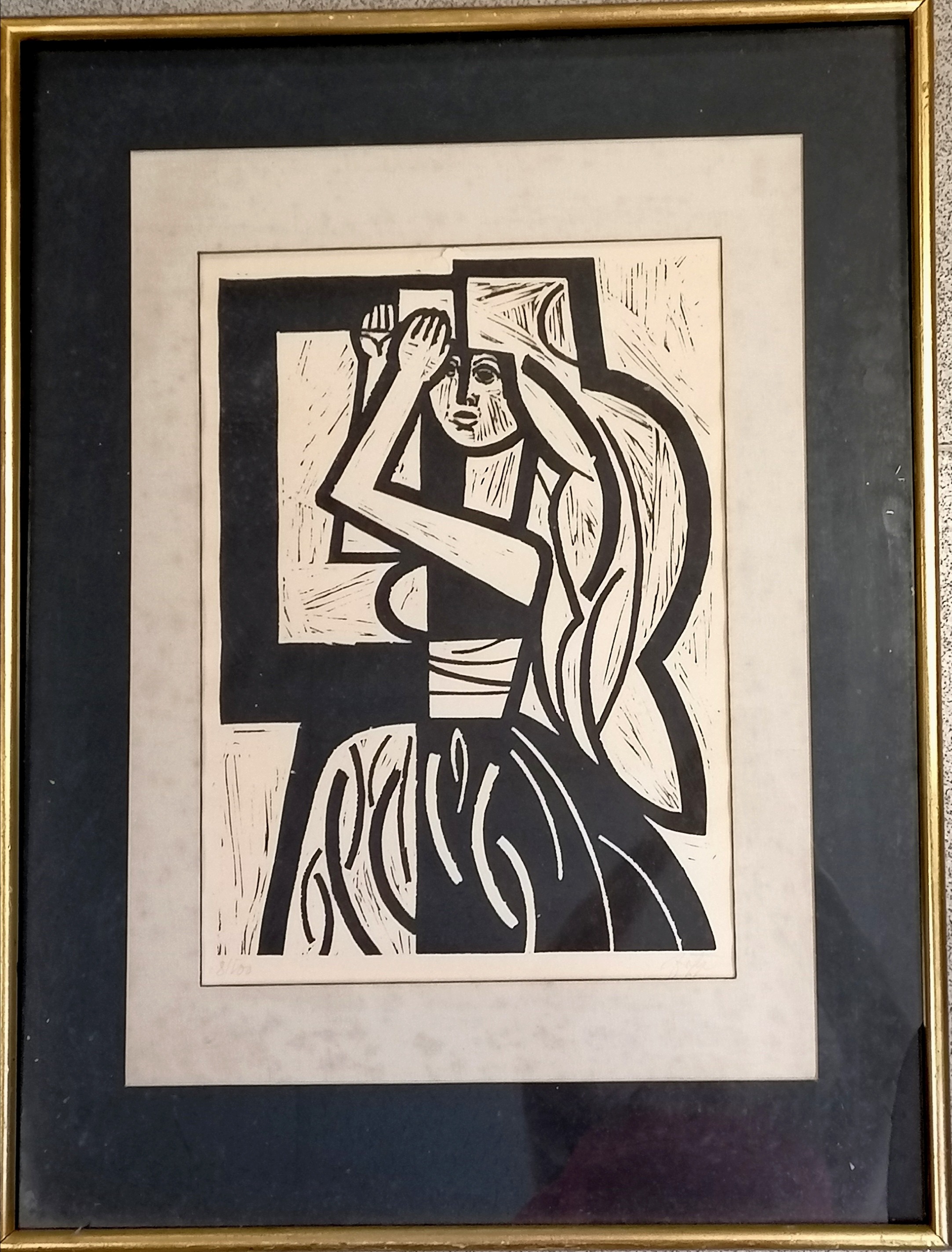 Signed woodblock print (#8/100) of a lady with long hair in a frame with a label on the reverse