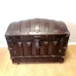 Antique domed wooden trunk with embossed metal decoration on casters. Has original lift out tray and
