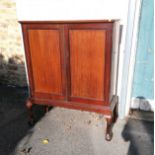 Circa 1900 mahogany cabinet on stand. Two panelled doors bearing ivorine tablet label "Old Times"