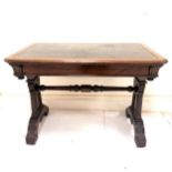 A Victorian mahogany writing table with green and gold tooled leather insert, canted corners, carved