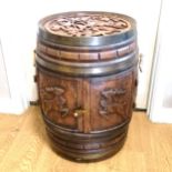 Oak barrel drinks cabinet with carved detail to the top and both door panels, on castors. 40cm