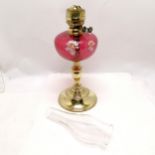 Antique brass oil lamp with cranberry glass reservoir with enamel flower decoration - total height