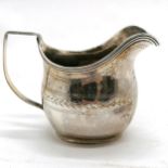 Antique silver cream jug, hallmarked London 1783. 122g. 7cm high. Has dents around the base and
