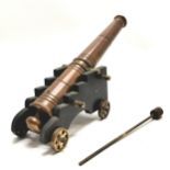 Bronze cast model of an antique cannon on wooden limber with maltese cross decoration and has ramrod