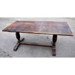 An early 20th century oak refectory dining table raised on carved acorns, terminating on splayed