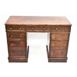 A Victorian stained wood pedestal desk, with an arrangement of six drawers and a cupboard door