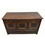 An 18th century and later carved oak coffer, with carved and panelled detail to the front above