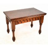 A late Victorian Gothic pine centre table with arched frieze and raised on ring turned legs to peg
