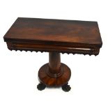 An early 19th century mahogany fold over tea table, raised on a central column terminating on four