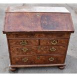 An 18th century burr walnut and feather and crossbanded bureau, the fall-front enclosing a fitted