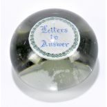 A Victorian glass paperweight, the interior inset with a silvered disc titled 'Letters to Answer',