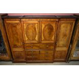 A George III mahogany four door breakfront wardrobe, the moulded cornice above two central oval