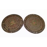 A pair of Buddhist wooden chargers with concentric bands of graduated motifs, diameter 49cm.