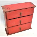 An early 20th century red painted pine three drawers chest, width 40cm, depth 14cm, height 39cm.