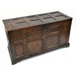 A large carved oak 18th century coffer with multi-panelled hinged lid and carved detail to the