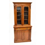 A late Victorian walnut bookcase on cupboard with glazed upper section, single drawer and twin