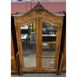 A French walnut armoire with two bevelled mirrored doors raised on carved cabriole front legs.