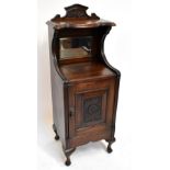 An Edwardian mirror back bedside cabinet, with carved door raised on cabriole legs.Additional