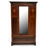 An Edwardian inlaid mahogany wardrobe, with moulded cornice, above single mirrored door, raised on