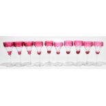 A near set of ten of cranberry tinted wine glasses, each with etched upper band of grapes and