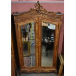 A French walnut armoire with two bevelled mirrored doors raised on carved cabriole front legs.