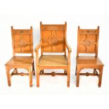 A set of three oak Gothic chairs, the larger elbow chair and twin side chairs set with