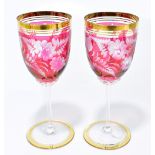 A pair of decorative Bohemian wine glasses each with etched floral detail and gilt rims, height 18.